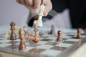 Close up shot hand of business woman playing the chess board to win by killing the king of opponent metaphor business competition