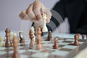 Close up shot hand of business woman playing the chess board to win by killing the king of opponent metaphor business competition