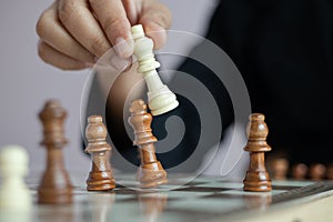 Close up shot hand of business woman playing the chess board to win by killing the king of opponent metaphor business competition