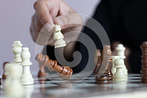 Close up shot hand of business woman playing the chess board to win by killing the king of opponent metaphor business competition