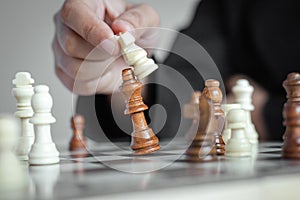 Close up shot hand of business woman playing the chess board to win by killing the king of opponent metaphor business competition