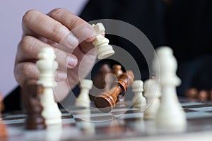 Close up shot hand of business woman playing the chess board to win by killing the king of opponent metaphor business competition