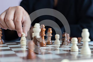 Close up shot hand of business woman playing the chess board to win by killing the king of opponent metaphor business competition