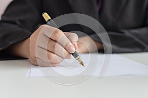 Close up shot hand of business woman using the pen to write on the white paper select focus shallow depth of field