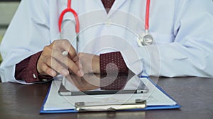 Close up shot hand of doctors with stethoscope are using tablets to write treatment reports or view patient information. New