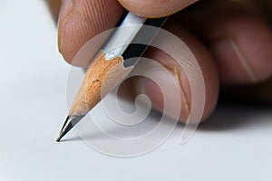 Close up shot of a hand holding pencil to write on white paper -Planning concept