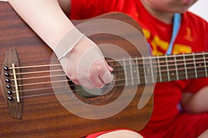 Close-up shot of hand playing guitar strings using a pick selective focus