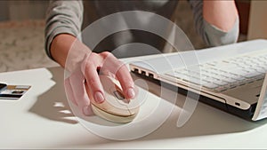 Close up shot of hand of woman and using mouse of laptop to make shoppin