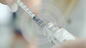 Close up shot of hands of Beautician doctor draws botox to a syringe and prepares to injection. Beauty technology