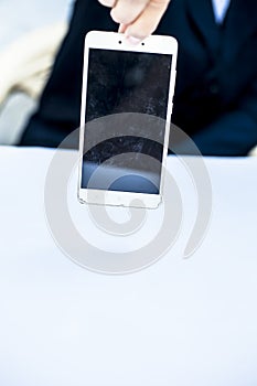 Close up of shot of hands of a business man wearing blue colored suit and holding a cell phone from the edge concept of loss in bu