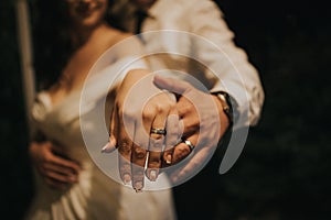 Close up shot on the hands of groom and bride showing their wedding rings