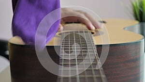 Close up shot hands of man cleaning up nylon guitar string, acoustic classical guitar maintaining for the best sound, select focus