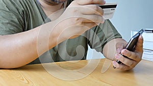 Close up shot hands of man using smart phone and holding credit card metaphor internet shopping mobile application and e business