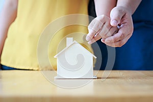 Close up shot hands of man and woman putting the coin to house p