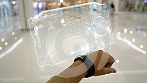 Close up shot hands of woman using smart watch with HUD user interface for cyber futuristic application and technology concep