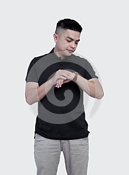 Close Up shot of handsome man wearing black polo shirt posing at plain background