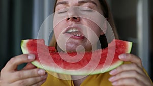 Close up shot of happy positive woman holds big slice of juicy watermelon enjoys eating her favorite summer fruit bites