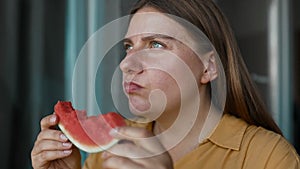 Close up shot of happy positive woman holds big slice of juicy watermelon enjoys eating her favorite summer fruit bites