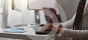 Close up shot of happy young woman working on computer, female hands typing on keyboard