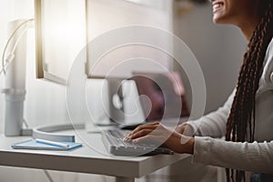 Close up shot of happy young woman working on computer, female hands typing on keyboard