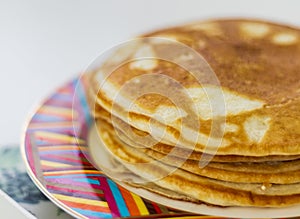 Close up shot of a home made pancakes on colorful plate. Food