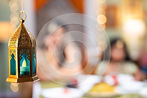 Close up shot of indain muslim family to hanging lantern while eating during ramadan iftar dinner at home - concept of