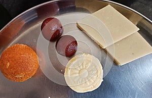 Close-up shot of Indian sweets like Ladoo, gulab jamun, Barfi and peda etc during Samba Dasami Festival