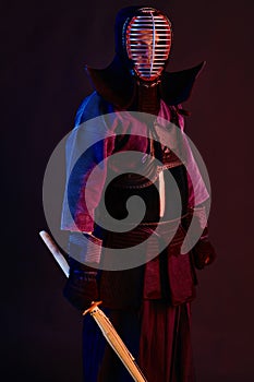 Close up shot, Kendo fighter wearing in an armor, traditional kimono, helmet practicing martial art with shinai bamboo