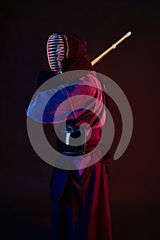 Close up shot, Kendo fighter wearing in an armor, traditional kimono, helmet practicing martial art with shinai bamboo