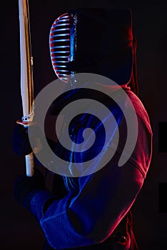 Close up shot, Kendo fighter wearing in an armor, traditional kimono, helmet practicing martial art with shinai bamboo