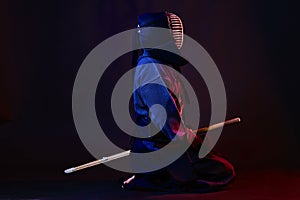 Close up shot, Kendo fighter wearing in an armor, traditional kimono, helmet practicing martial art with shinai bamboo