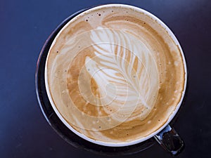 Close up shot of a latte coffee with leaf shap art