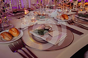 Close up shot of a luxury alfresco wedding reception table set up at the countryside; crystal tableware and burning candles