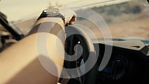 Close up shot of male hand on car steering wheel.