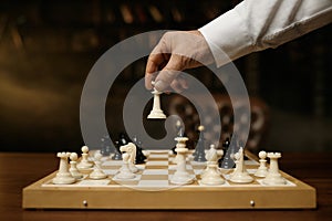 Close up shot of male hand moving chesspiece on chessboard photo