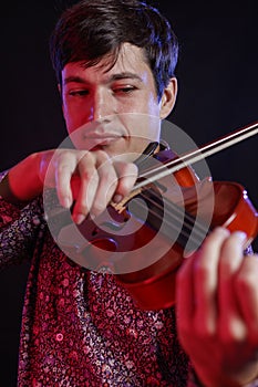 Close up shot of male musician playing violin. Black background