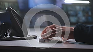 Close up shot of male security operator typing on keyboard