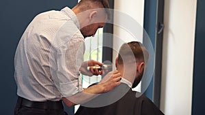 Close up shot of man getting trendy haircut at barber shop. Male hairstylist serving client, making haircut using