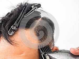 Close up shot of man getting trendy haircut. Male hairstylist serving client, making haircut using machine and comb. the concept