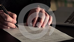 Close up shot of man`s hands, who leaves signature on the agreement.