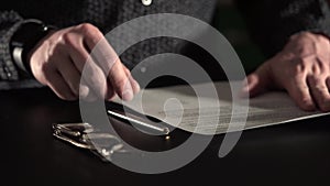 Close up shot of the man`s hands, who signing documents, selective focus.