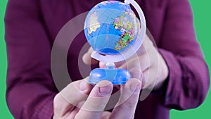 Close-up shot of man`s hands who is a travel agent keeping a globe,demonstrating a big variety of traveler`s locations on the