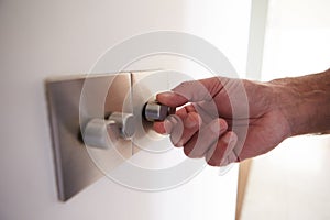 Close Up Shot Of Man Turning Down Electrical Dimmer Switch