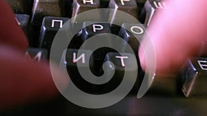 Close up shot man typing on old vintage typewriter with Russian letters backlit news, media or communication concept. Blue toning.