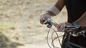 Close-up shot of mans hands holding handlebar of bicycle