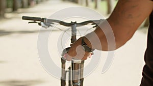 Close-up shot of mans hands holding seat of bike
