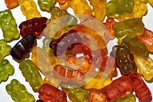 Close up shot of many tasty colorful gummy bears made from fruit juice, gelatin and sugar isolated over white background