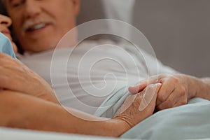 Close-up shot of married couple keeping hands together