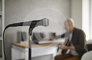 Close up shot of microphone on rack standing in music studio on background of musician.