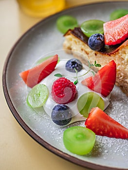 Close-up shot of mixed berries and whipped cream in a plate of cheesecake